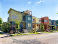 Digital watercolor of the iconic Crayola Box row townhomes on Tenacity Drive in summer morning light, Prospect New Town, Longmont, Colorado, in the combined style of Sargent and Renoir.