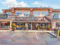 Dreamy Renoir-style watercolor of The Winot Cafe, featuring sun-drenched ochre washes, a vibrant awning, and a warm interior glow.